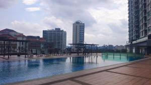 SAFIYA Roomstay Vista Alam في شاه عالم: بركة كبيرة من المياه في مدينة بها مباني