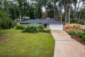 a house with a yard with a driveway at The Monterey -- Private Pool & Grill - 4 KING Beds in Gainesville