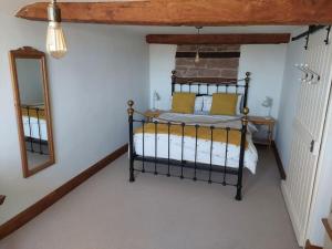 1 dormitorio con cama negra y espejo en Ross on Wye The Old Wool Merchants House, en Ross-on-Wye