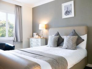 a bedroom with a large bed with a window at Britannia Hotel Newcastle Airport in Newcastle upon Tyne