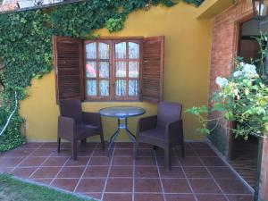 ミナ・クラベロにあるApart hotel La Posaditaのパティオ(椅子2脚、テーブル、窓付)
