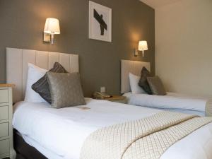 a hotel room with two beds and two lamps at Britannia Hotel Newcastle Airport in Newcastle upon Tyne