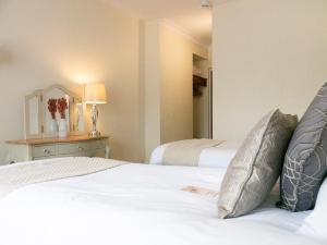 a bedroom with two beds and a table with a lamp at Britannia Hotel Newcastle Airport in Newcastle upon Tyne