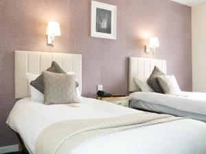 a hotel room with two beds and two lamps at Britannia Hotel Newcastle Airport in Newcastle upon Tyne