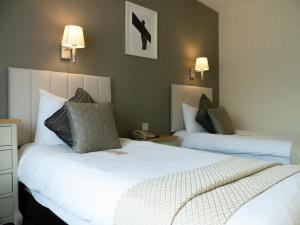 a hotel room with two beds and two lamps at Britannia Hotel Newcastle Airport in Newcastle upon Tyne