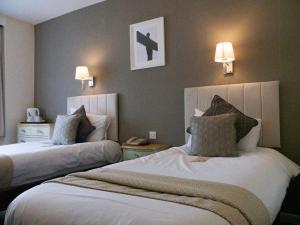 a hotel room with two beds and two lamps at Britannia Hotel Newcastle Airport in Newcastle upon Tyne