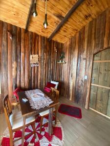 a dining room with a table and chairs and wooden walls at Pousada Vale de Luz FW in Frederico Westphalen