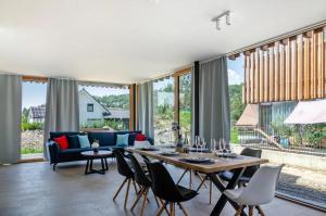 a living room with a table and chairs at LakeSide - exklusives Architektenhaus C5 mit Seesicht auf der Höri in Öhningen