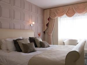 a bedroom with a large white bed with a window at Britannia Hotel Newcastle Airport in Newcastle upon Tyne