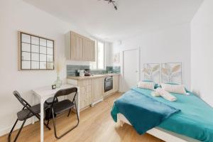 a bedroom with a bed and a desk and a kitchen at Le Clichy Chic in Clichy +11 photos