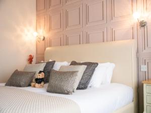 a teddy bear sitting on a bed with pillows at Britannia Hotel Newcastle Airport in Newcastle upon Tyne