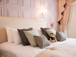 a teddy bear sitting on a bed with pillows at Britannia Hotel Newcastle Airport in Newcastle upon Tyne