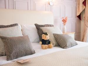 a teddy bear sitting on a bed with pillows at Britannia Hotel Newcastle Airport in Newcastle upon Tyne
