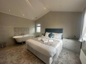 a bedroom with a bed and a bathtub and a bed and a bathtub at WH - Smugglers Lodge in Aberaeron