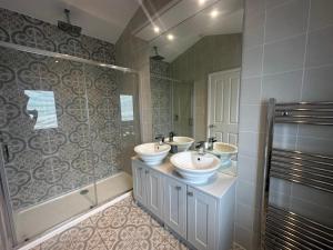 a bathroom with two sinks and a shower at WH - Smugglers Lodge in Aberaeron +4 photos