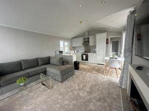 a living room with a couch and a kitchen at WH - Smugglers Lodge in Aberaeron
