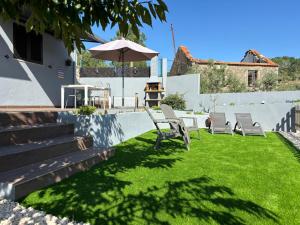 un cortile con due sedie e un ombrellone di Quinta Santo Antonio a Gouveia