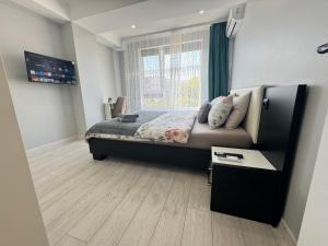 a bedroom with a large bed with a window at Near Airport Cozy Apartment in Codru