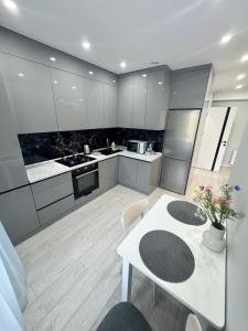 a large kitchen with a white table and chairs at Near Airport Cozy Apartment in Codru