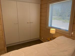 una camera con letto, finestra e lampada di Miilu Resort a Ylläsjärvi