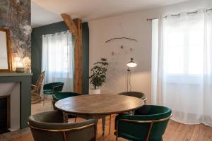 une salle à manger avec une table en bois et des chaises vertes dans l'établissement Le Leon Bourgeois 6 personnes hypercentre Epernay, à Épernay