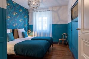 - une chambre avec un lit aux murs bleus et un lustre dans l'établissement Le Leon Bourgeois 6 personnes hypercentre Epernay, à Épernay