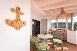 a room with a table and chairs and a kitchen at Ático San Agustín in La Lajita +15 photos