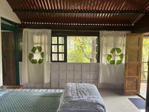ein Schlafzimmer mit einem Bett und einem Fenster in der Unterkunft Treehouse at Kamp in Dhanwār