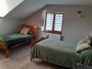 a bedroom with two beds and a window at Pod Żurawiem in Bóbrka