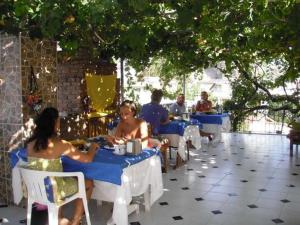 a group of people sitting at tables in a restaurant at Kristal pansiyon in Dalyan
