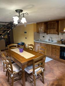 a kitchen with a wooden table and wooden chairs at Casa Serena in Massarosa