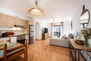 a large kitchen and living room with a couch at Apartamento La Falúa in Lajita
