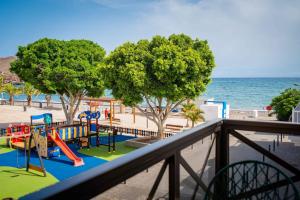 a playground on the beach next to the ocean at Apartamento La Falúa in Lajita