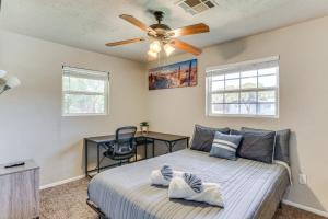 a bedroom with a bed with a ceiling fan and a desk at 4 Mi to Museum of the Great Plains Lawton Home! in Lawton