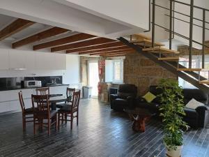 a kitchen and a living room with a table and chairs at Casa do Jardim in Guimarães