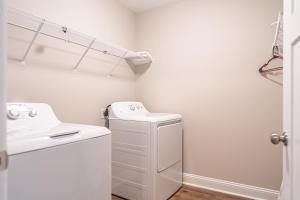 a white laundry room with a washer and dryer at The Dogwood at Ducks Landing in Aberdeen