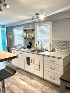 Una cocina con gabinetes blancos y un fregadero. en 1 Bedroom, steps to the Beach, en Old Orchard Beach