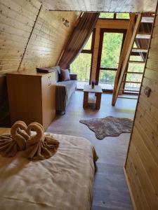 a room with a bed and a couch in a house at A-Frame Bella in Zăvoi