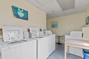 una habitación con lavadoras blancas y una mesa en Cozy 1-Bedroom Suite Steps from the Beach (464), en Old Orchard Beach