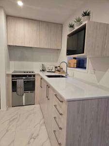a kitchen with a sink and a stove top oven at CBD Apartment 3 - 2 Bed 2 Bath in Christchurch +5 photos
