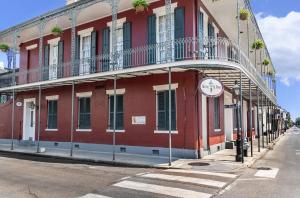 a red building with a clock on the side of it at Inn on St. Peter, a French Quarter Guest Houses Property in New Orleans