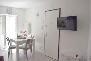 a dining room with a table and a tv on a wall at Dimora Vima in Monopoli