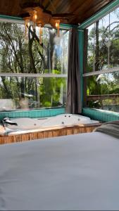 a bath tub sitting in front of a window at Pousada Vale de Luz FW in Frederico Westphalen