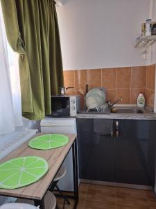a kitchen with a table with green plates on it at Anna Home in Râmnicu Vâlcea