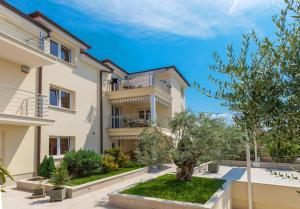 a villa with a garden in front of a building at BOZIDAR in Selce