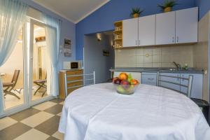 a kitchen with a bowl of fruit on a table at BOZIDAR in Selce +30 photos