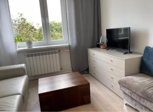 a living room with a couch and a tv on a dresser at es studio in Staszów