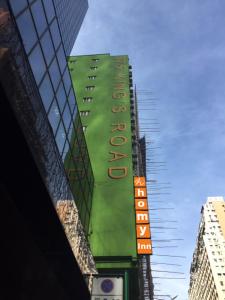 a tall green building with a hotel sign on it at Homy Inn North Point in Hong Kong
