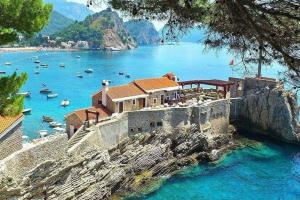 a house on the shore of a body of water at Zen Olive Retreat in Petrovac na Moru