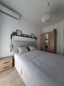 ペトロヴァック・ナ・モルにあるZen Olive Retreatのベッドルーム1室(白い大型ベッド1台、木製キャビネット付)